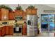 Kitchen featuring stainless steel appliances and wood cabinetry overlooking the outdoor pool at 5868 Jefferson Rd, Venice, FL 34293