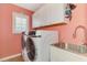 Bright laundry room with modern washer and dryer, sink, ample counter space, and storage at 5868 Jefferson Rd, Venice, FL 34293