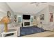 Cozy living room featuring a fireplace, large television, and comfortable seating area at 5868 Jefferson Rd, Venice, FL 34293