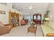 Spacious living room with wicker furniture, a bookcase, and a view into the dining area at 5868 Jefferson Rd, Venice, FL 34293