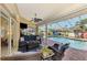 Covered patio features a seating area and a screened-in pool with a paver deck at 5868 Jefferson Rd, Venice, FL 34293