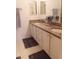 Bathroom with double sinks, granite counters, white cabinets, and decorative towels at 603 Auburn Lakes Cir # 603, Venice, FL 34292