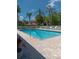 Inviting community pool featuring crystal-clear water, lounge chairs, palm trees, and brick-paver surround at 603 Auburn Lakes Cir # 603, Venice, FL 34292