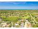 Stunning aerial view of the property showcasing the community, nearby golf course, and ocean views at 622 Pine Ranch East Rd, Osprey, FL 34229