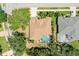 An aerial view shows the house with a brown roof and screened in pool, surrounded by lush landscaping at 622 Pine Ranch East Rd, Osprey, FL 34229