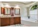 Bright bathroom featuring a large soaking tub, granite countertops, and dual sinks at 622 Pine Ranch East Rd, Osprey, FL 34229