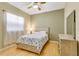 Cozy bedroom featuring a ceiling fan, bright window, and hardwood floors at 622 Pine Ranch East Rd, Osprey, FL 34229