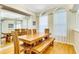Sunlit formal dining room with an oversized wood table, wood bench, and lots of natural light at 622 Pine Ranch East Rd, Osprey, FL 34229