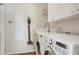 Convenient laundry room with washer, dryer, and storage cabinets at 622 Pine Ranch East Rd, Osprey, FL 34229
