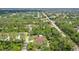 An aerial view circles the new home nestled within lush woods offering a secluded oasis at 66 Statler St, Port Charlotte, FL 33954