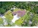 An aerial view showcases a home with a spacious yard, surrounded by lush trees and greenery at 66 Statler St, Port Charlotte, FL 33954