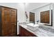 Bathroom with a marble countertop, dark wood cabinets, and a brown door at 66 Statler St, Port Charlotte, FL 33954
