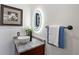 A modern half-bathroom with an oval mirror and a marble countertop provides convenience and style at 66 Statler St, Port Charlotte, FL 33954