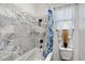A luxurious tub features striking marble-look tile extending from the floor to the ceiling at 66 Statler St, Port Charlotte, FL 33954