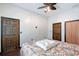 Comfortable bedroom featuring a ceiling fan, two doors, and a large floral bedspread at 66 Statler St, Port Charlotte, FL 33954