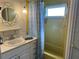 Bright bathroom featuring single sink vanity, shower with curtain, and decorative mirror at 6741 Laurel Ct, North Port, FL 34287