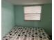 Cozy bedroom featuring paneled walls, neutral bedding, and a window with light-filtering blinds at 6741 Laurel Ct, North Port, FL 34287