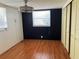 Spare bedroom with laminate flooring, black accent wall, and sliding closet doors at 6741 Laurel Ct, North Port, FL 34287