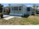 Charming home featuring light green siding, a covered carport, and a small front garden on a sunny day at 6741 Laurel Ct, North Port, FL 34287