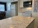 Bright kitchen with a marble countertop island, white appliances, and stylish lighting fixtures at 6741 Laurel Ct, North Port, FL 34287