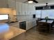Modern kitchen with white cabinets, stainless steel appliances, and a dining area with table and chairs at 6741 Laurel Ct, North Port, FL 34287
