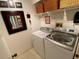 Bright laundry room features a modern washer, dryer, and ample basket storage on a high shelf at 7560 Fairway Woods Dr # 305, Sarasota, FL 34238