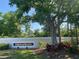 The Fairway Woods sign is surrounded by manicured landscaping and mature trees at 7560 Fairway Woods Dr # 305, Sarasota, FL 34238