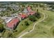 Aerial view showcases the condo buildings, golf course with water hazard, walking paths and parking at 770 Village Cir # 232, Venice, FL 34292