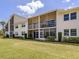 Back of condo building with screened patios and a well-maintained lawn at 770 Village Cir # 232, Venice, FL 34292