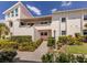 Exterior of condo unit with a well-maintained lawn and lush landscaping at 770 Village Cir # 232, Venice, FL 34292