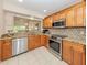 Spacious kitchen with granite countertops, stainless steel appliances, and wood cabinetry at 770 Village Cir # 232, Venice, FL 34292