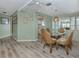 Dining room with luxury vinyl floors and view of the kitchen, living room, and screened lanai at 798 Fairmount Dr, North Port, FL 34287