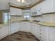 Updated kitchen featuring white cabinets, a dishwasher, and vinyl flooring at 798 Fairmount Dr, North Port, FL 34287