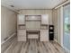 Office featuring built-in desk and storage cabinets, a water cooler, and wood-look flooring at 798 Fairmount Dr, North Port, FL 34287