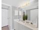 Bright bathroom with double sinks, white cabinets, large mirror, and modern lighting fixture at 819 Montrose Dr # 102, Venice, FL 34293