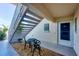 Cozy condo entrance with outdoor seating area, covered stairs, and well-maintained exterior details at 819 Montrose Dr # 102, Venice, FL 34293