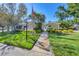 Landscaped walkway leading to the entrance of the villa under a bright blue sky at 819 Montrose Dr # 102, Venice, FL 34293