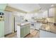 Bright kitchen featuring white cabinets, granite counters, and an island at 819 Montrose Dr # 102, Venice, FL 34293