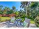 Patio featuring outdoor seating, lush tropical plants, and a sunny sky at 819 Montrose Dr # 102, Venice, FL 34293