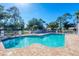 Community pool surrounded by a brick patio and lush green landscaping at 819 Montrose Dr # 102, Venice, FL 34293