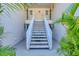 Welcoming condo entrance with staircase leading to upper units, surrounded by lush tropical landscaping at 819 Montrose Dr # 102, Venice, FL 34293