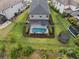 An aerial view of the backyard, it shows the fenced yard with a pool, screen enclosure, and trampoline at 8304 Shooting Star Rd, Sarasota, FL 34241