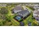Aerial view of the home showcases a fenced yard, a pool, with an enclosed screen and a trampoline at 8304 Shooting Star Rd, Sarasota, FL 34241