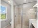 Bright bathroom featuring glass enclosed shower, updated fixtures and a view to the neighborhood at 8304 Shooting Star Rd, Sarasota, FL 34241