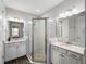 Bathroom featuring double sinks, granite countertops, and a glass shower with pebble flooring at 8304 Shooting Star Rd, Sarasota, FL 34241