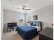 Bright bedroom features a ceiling fan, natural light, and neutral paint and carpet, with a dark wood desk at 8304 Shooting Star Rd, Sarasota, FL 34241