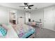 Bright bedroom with colorful floral bedding, ceiling fan, and a desk area with a plush chair at 8304 Shooting Star Rd, Sarasota, FL 34241