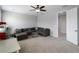 Cozy bonus room features comfortable gray sectional seating, plush carpet, and a modern ceiling fan at 8304 Shooting Star Rd, Sarasota, FL 34241