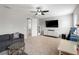 Spacious bonus room features a ceiling fan, wall-mounted TV, modern white cabinet and comfortable gray loveseat at 8304 Shooting Star Rd, Sarasota, FL 34241