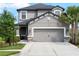 Charming home featuring a two-car garage with stone accents and a well-manicured lawn at 8304 Shooting Star Rd, Sarasota, FL 34241